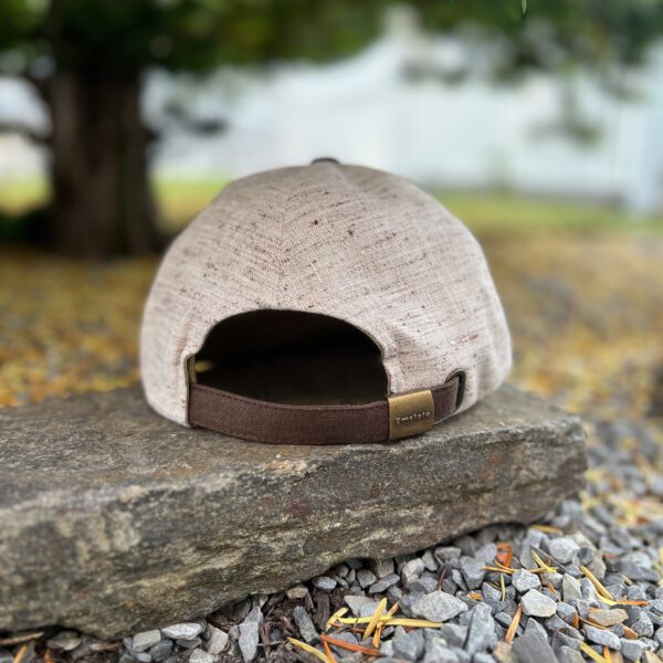 A hat is sitting on the ground near some rocks.